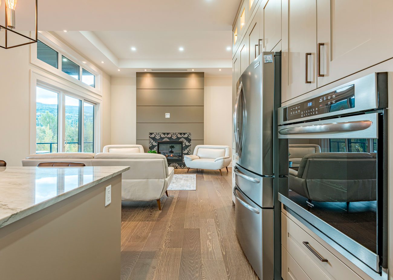 Sleek kitchen with stainless steel appliances, island seating, and open-concept living space.